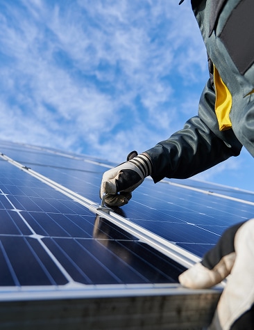 Climatiseur mural et salon moderne ensoleillé Climatiseur mural blanc moderne au-dessus d'un canapé gris clair, avec la lumière du soleil filtrant par une grande fenêtre. Ambiance intérieure lumineuse.