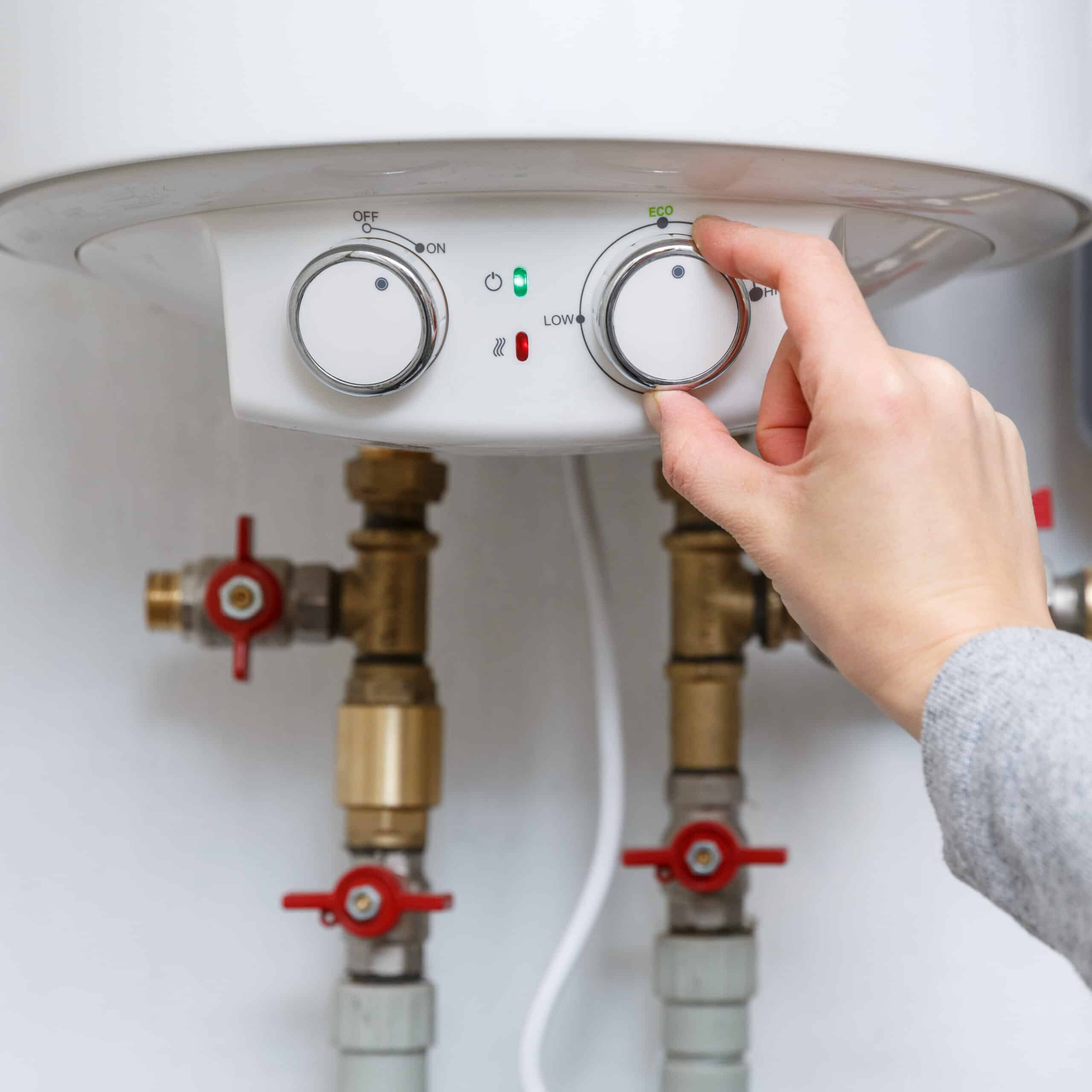 Climatiseur mural blanc moderne au-dessus d'un canapé gris clair, avec la lumière du soleil filtrant par une grande fenêtre. Ambiance intérieure lumineuse.