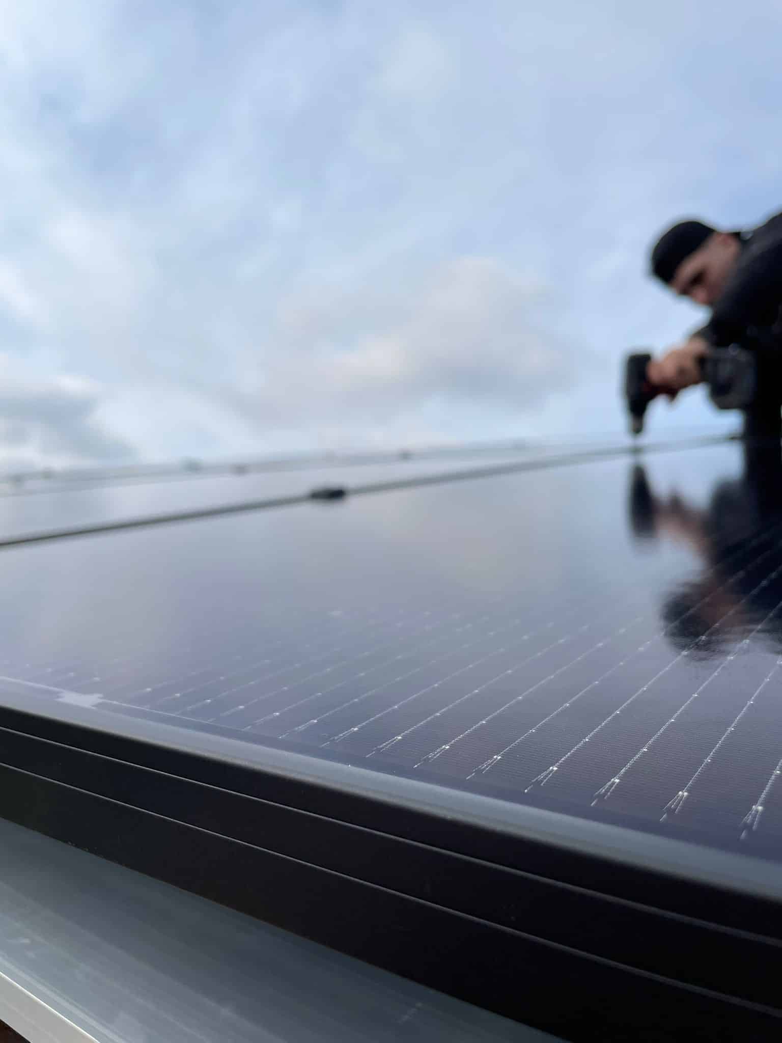 Climatiseur mural et salon moderne ensoleillé Climatiseur mural blanc moderne au-dessus d'un canapé gris clair, avec la lumière du soleil filtrant par une grande fenêtre. Ambiance intérieure lumineuse.